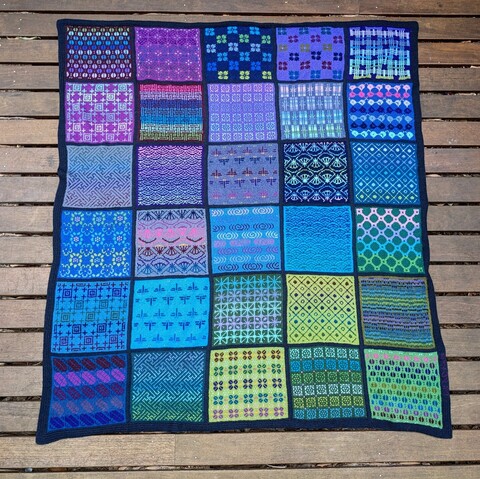 Knitted blanket in shades of blues green and purples with Japanese motifs
