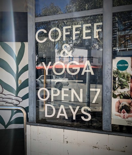 A window sign that reads:
"
Coffee
&
Yoga
Open 7
Days
"