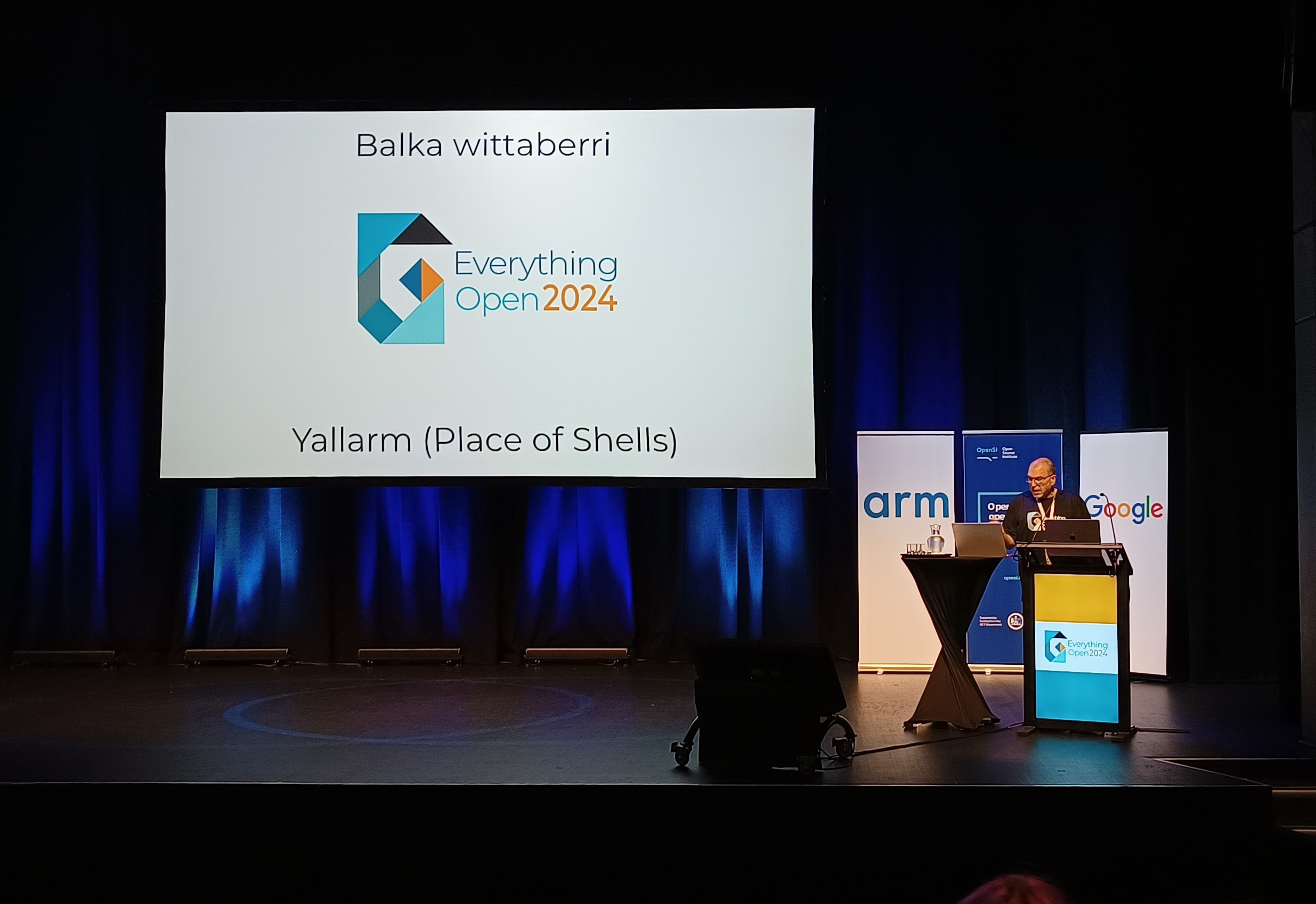 Rob Thomas on stage with slide reading:
Balkan wittaberri
Yallarm (Place of Shells)