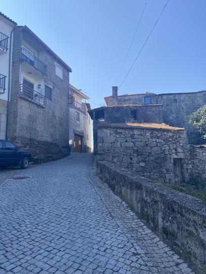 A cobbled street winds up between old buildings 