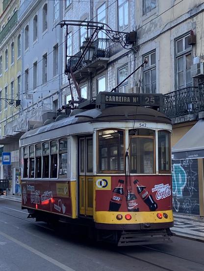 An old tram with buildings behind 