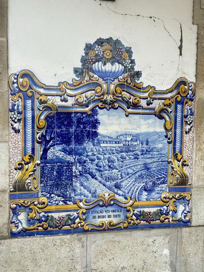 An elaborately painted tiled wall, depicting terraced vineyards above a river