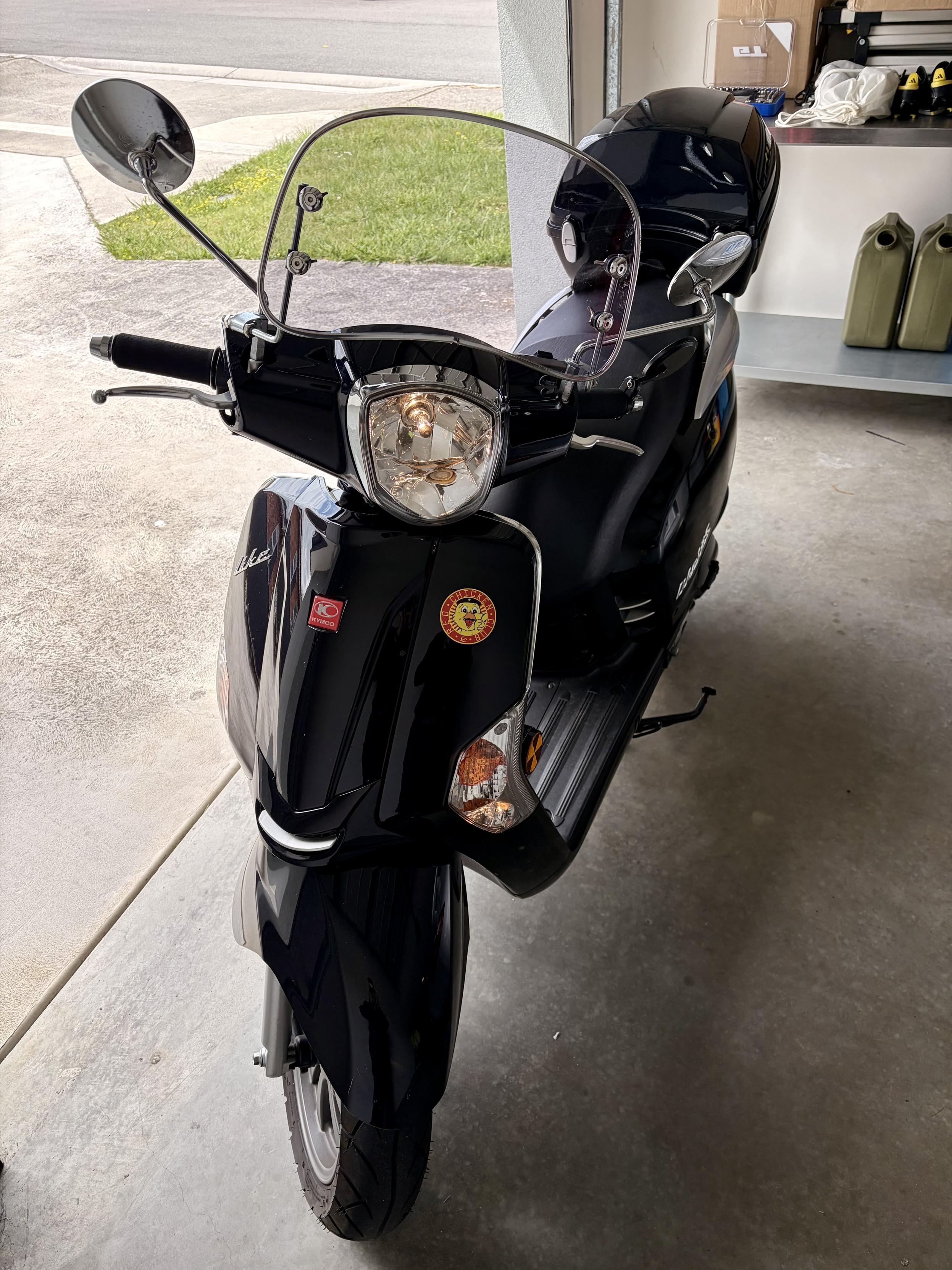 The back scooter now has a tinted windscreen and a top case. It is in the same position as before.