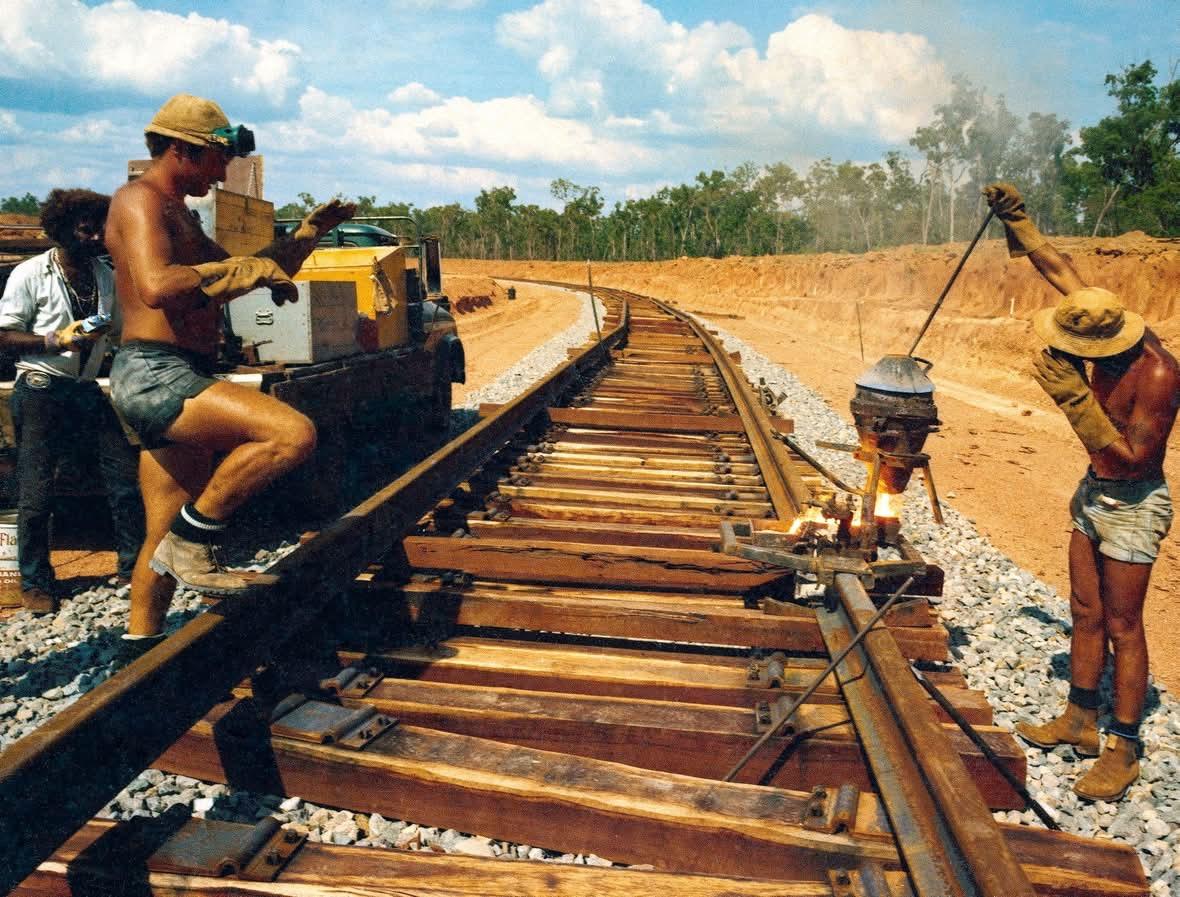 Railway workers starting a thermite rail weld on the under-construction Weipa to Andoom railway in Far North Queensland, 1971. The workers are wearing heavy duty welding gloves, goggles and hats but also no shirts and only stubbie shorts.
📸: Wolfgang Sievers, now in National Archives of Australia, reference “B942, ALUMINIUM”, item ID 30780032