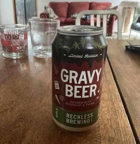 A can of “Gravy Beer” on a table. The label indicates that it is from Reckless Brewing, is infused with thyme and rosemary, and is to be enjoyed on Dec 21.