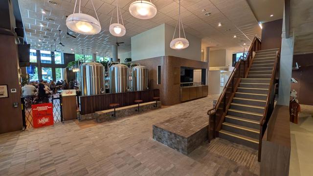 A wide view of the rear of the Lager House venue in East Trades Hall. There's a lot of interesting brown brickwork, a flight of stairs to the right an a small, unoccupied service area (possibly will be the Sliceria?)