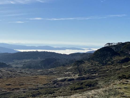 A view across mountains with low cloud in the valley under blue skies 
