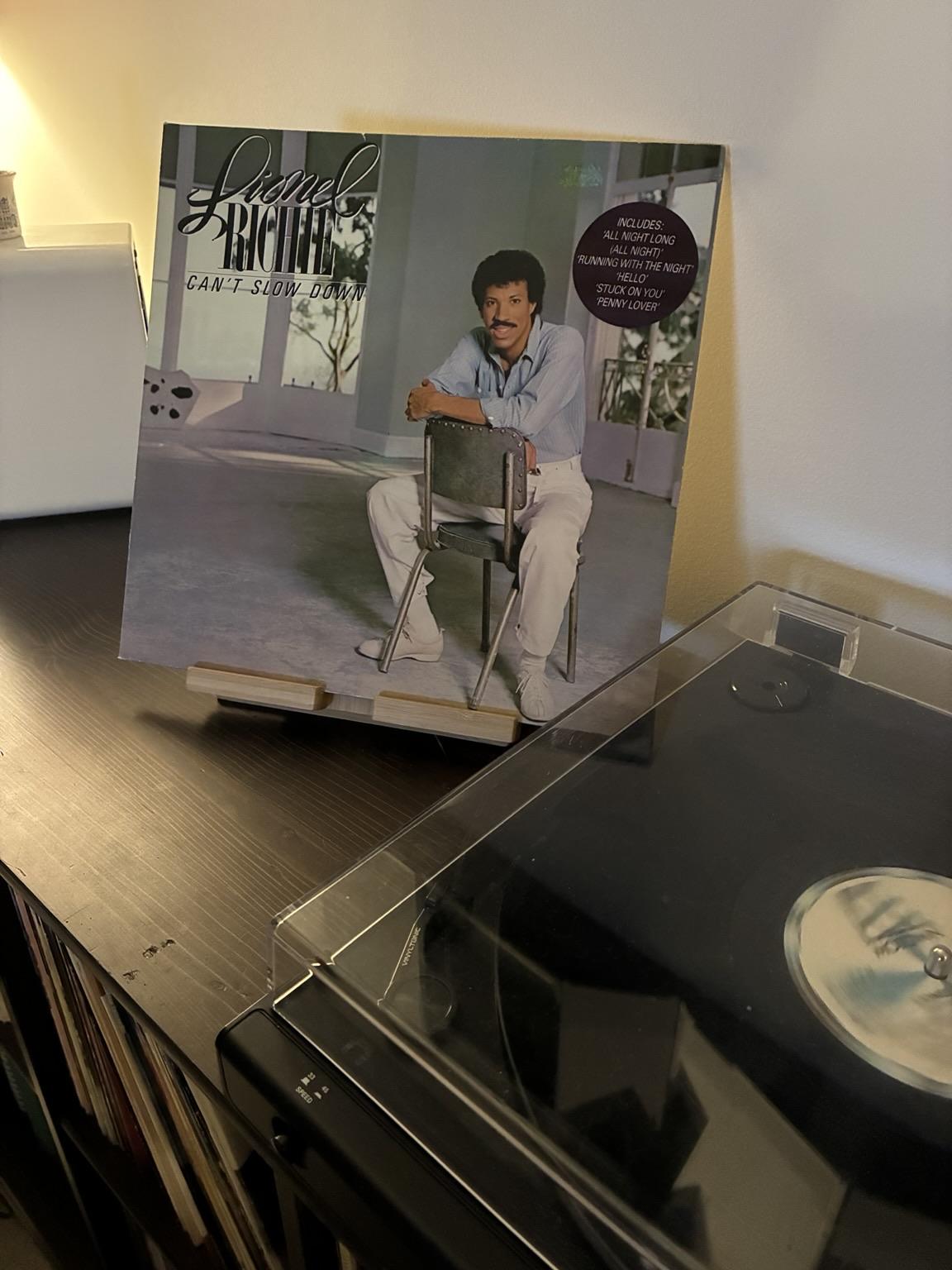 vinyl record cover of Lionel Ritchie’s Can’t Slow Down, displayed next to a turntable playing the record