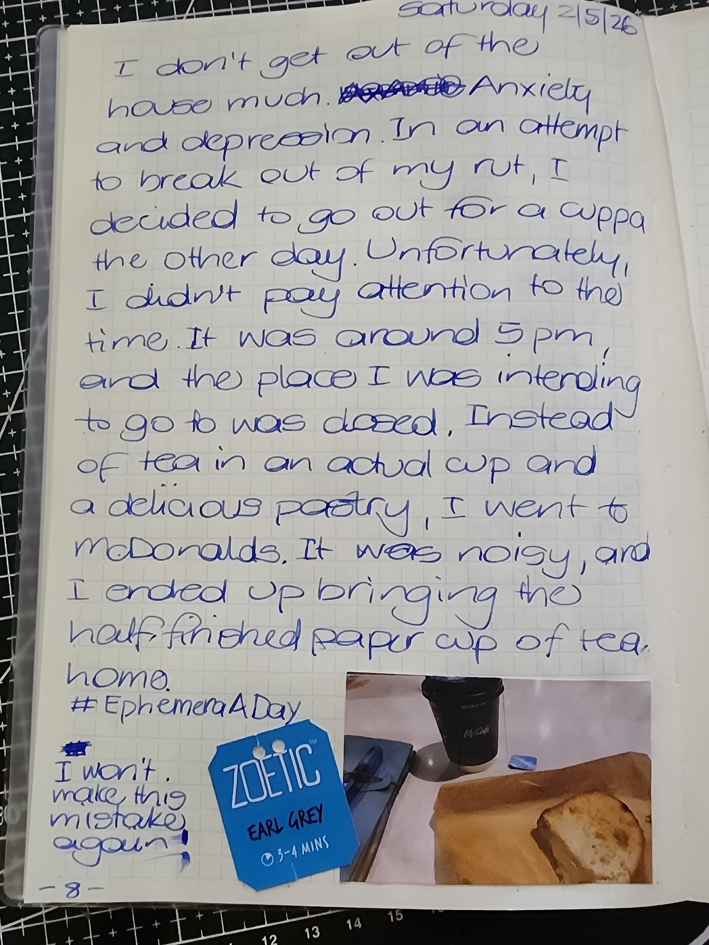A page from my journal for the 2nd of May.
"I don't get out of the house much. Anxiety and depression. In an attempt to break out of my rut, I decided to go out for a cuppa the other day. Unfortunately, I didn't pay attention to the time. It was around 5pm, and the place I was intending to go to was closed. Instead of tea in an actual cup and delicious pastry, I went to McDonalds. It was noisy, and I ended up bringing the half-finished paper cup of tea home. #EphemeraADay. I won't make this mistake again!"
A tag from a tea bag is next to a photo showing a sad-looking paper cup of tea and part of a toasted sandwich.