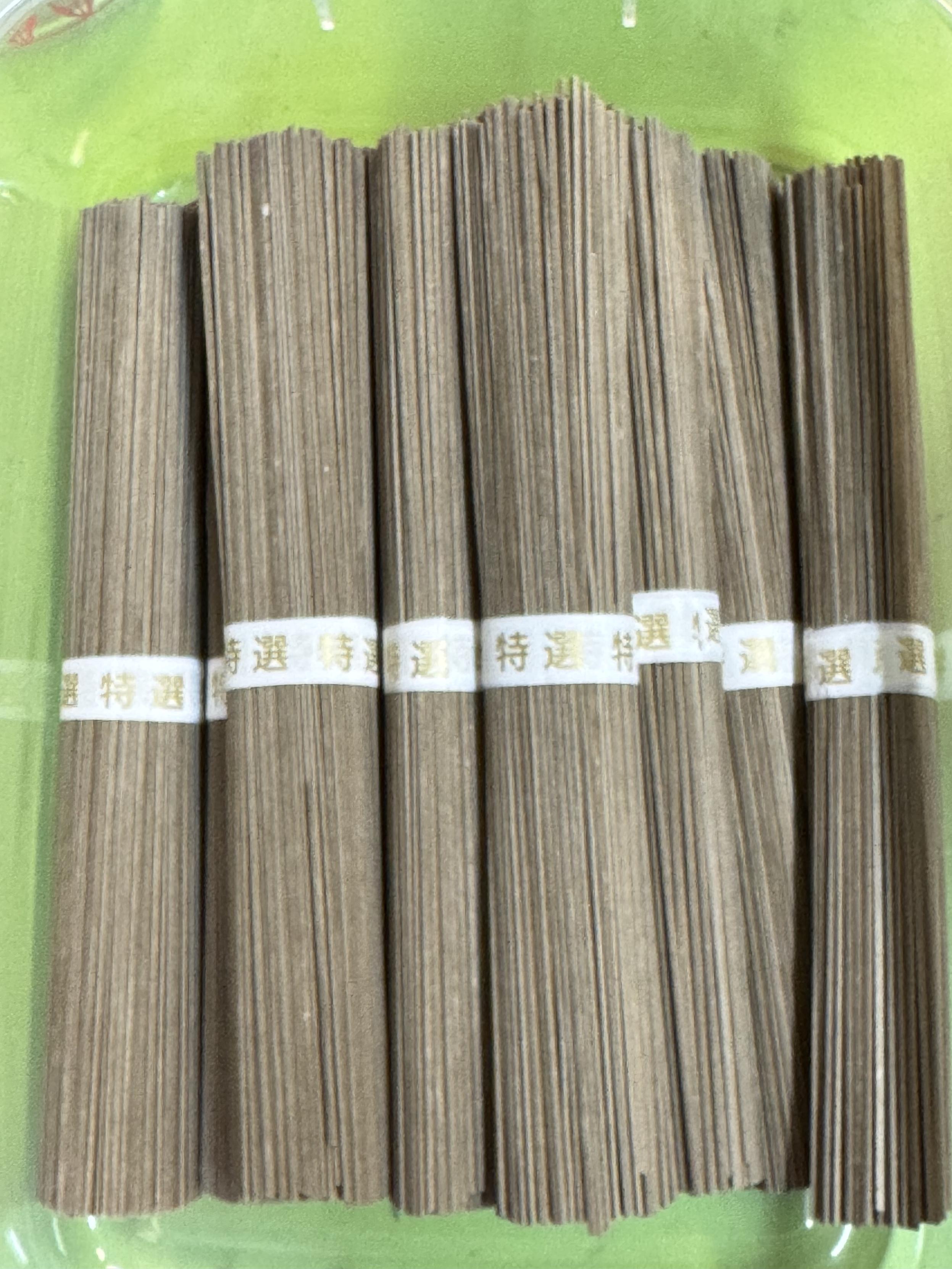 Bundles of individual brown noodles held together with paper bands around the middle of each bundle.