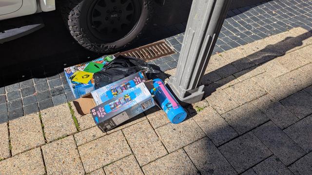A pile of large and colourful discarded nitrous oxide cylinders and cardboard boxes on a Perth curbside.