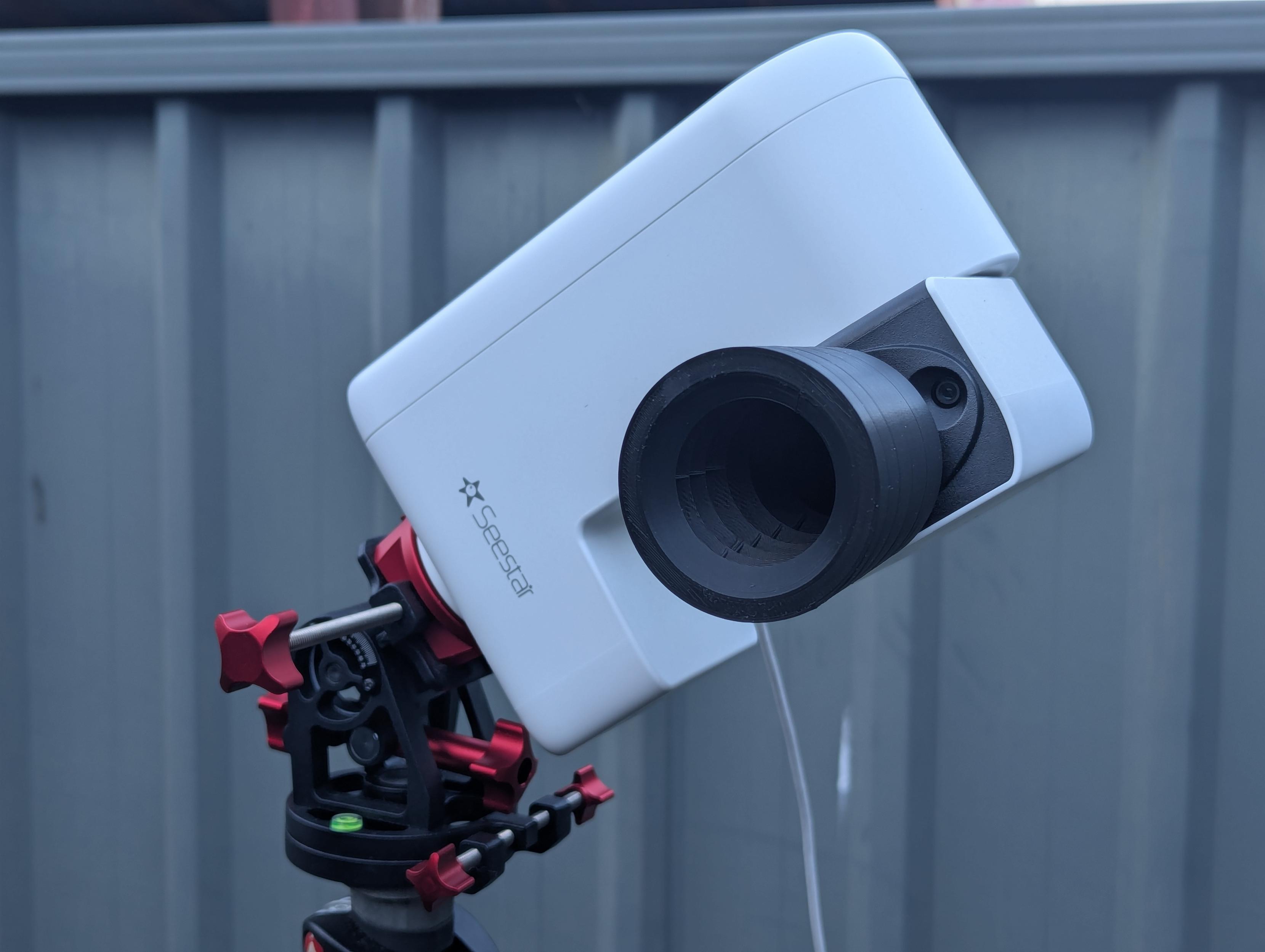 Photo of a Seestar S30 Pro attached to an equatorial wedge. The telescope arm is open, and a lens hood is attached.