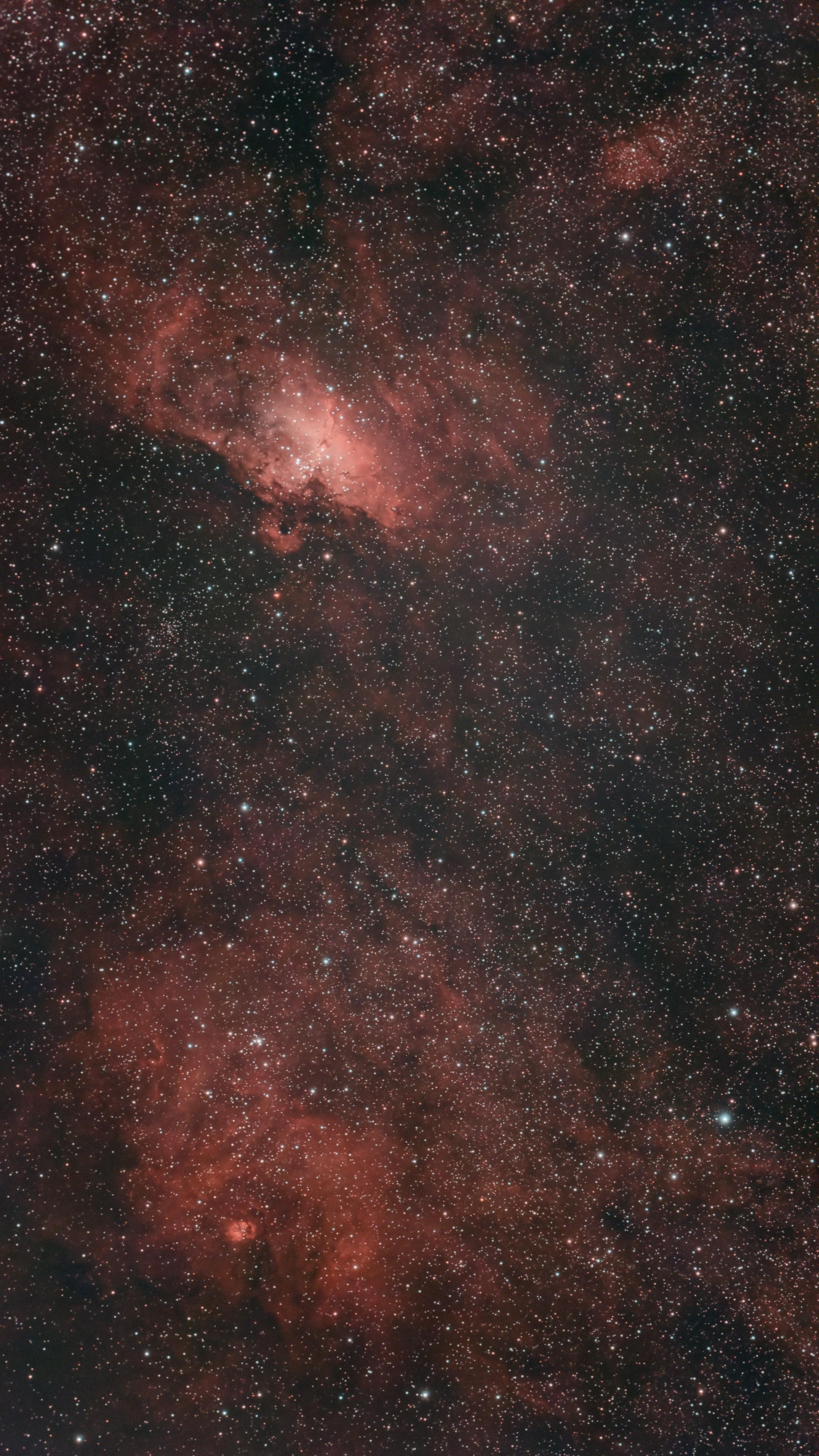 Astrophotograph showing the Eagle Nebula (home of the Hubble Space Telescope's "Pillars of Creation") above a larger, more diffuse nebula.