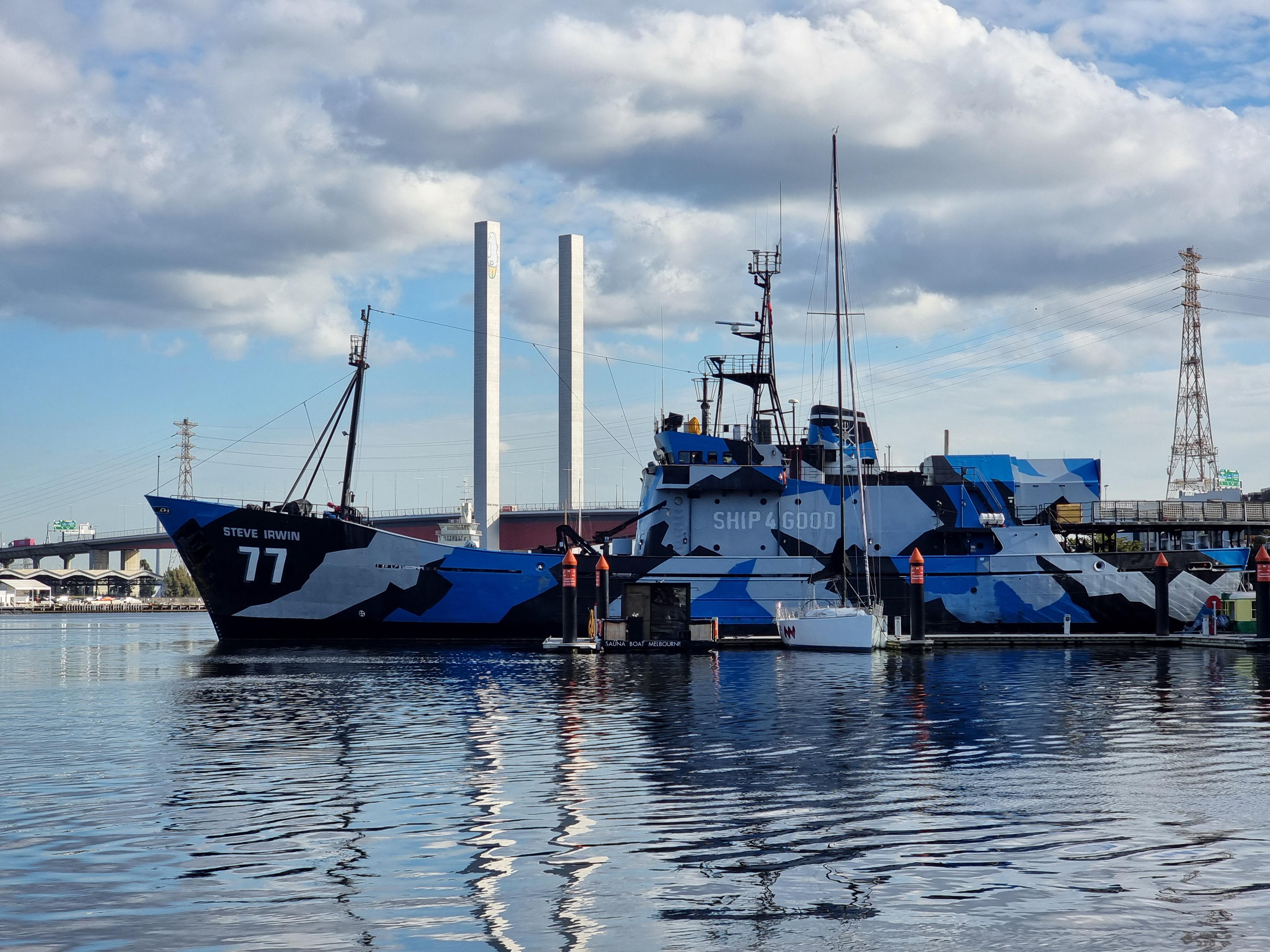 A Sea Shepherd ship in the foreground, "Pam the bird" graffiti on the Bolte Bridge in the background
