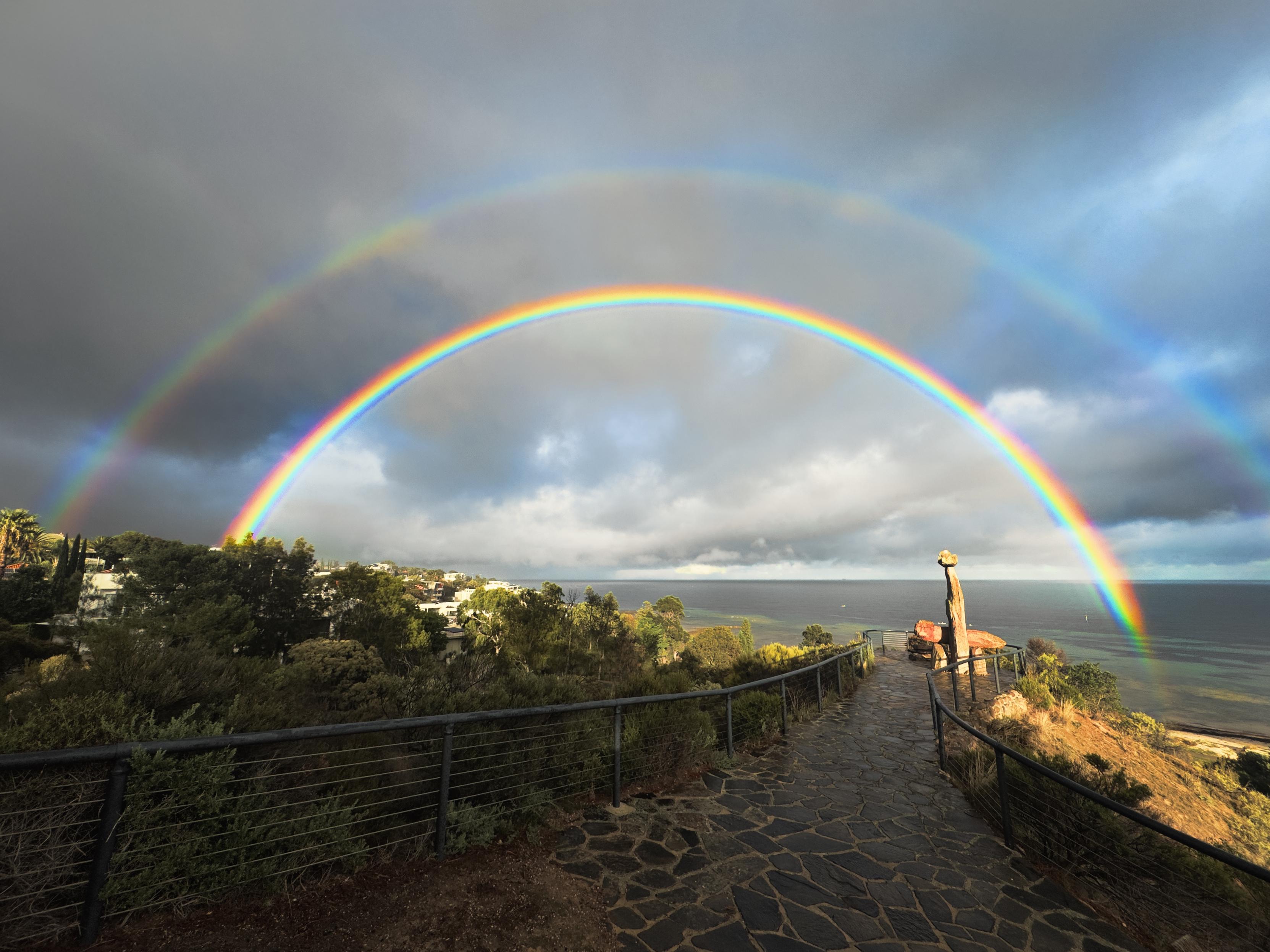 A double rainbow early in the morning over the Tjilbruke Monument in Kingston Park, South Australia. Alexander's dark band is clearly visible and you can see hints of the supernumerary bows at the bottom edges and faintly at the top of the bow.