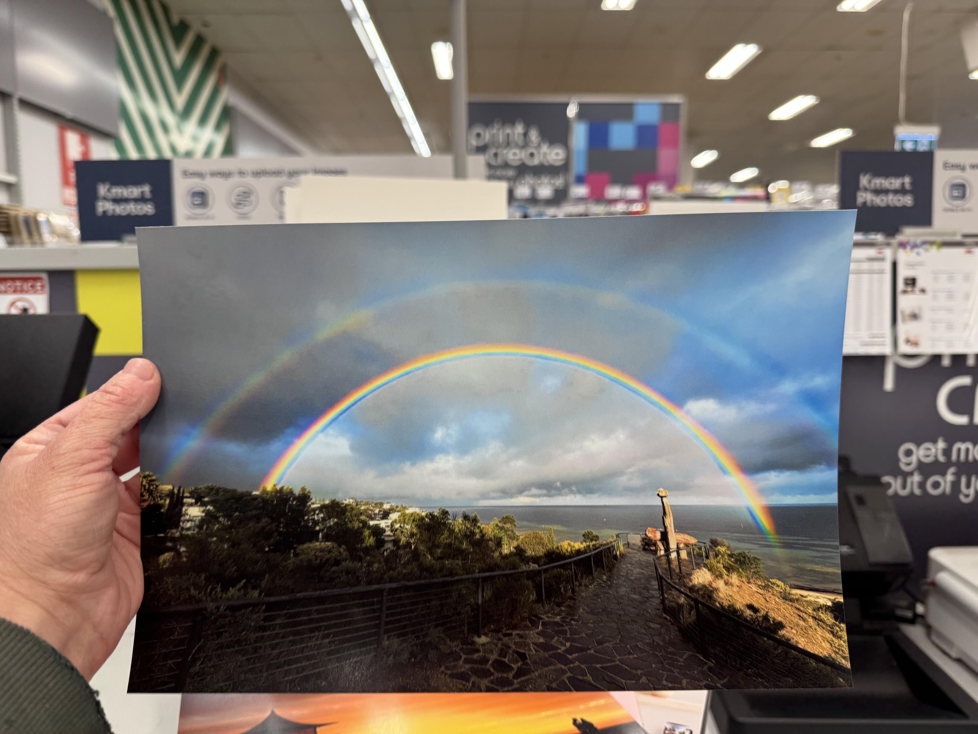 Holding up the printed photograph in the Kmart, fresh off the Kodak Memories dye-sub printer. The rich chroma of the rainbow has been preserved well and that colours are vibrant throughout. sRGB. Convert things to sRGB.