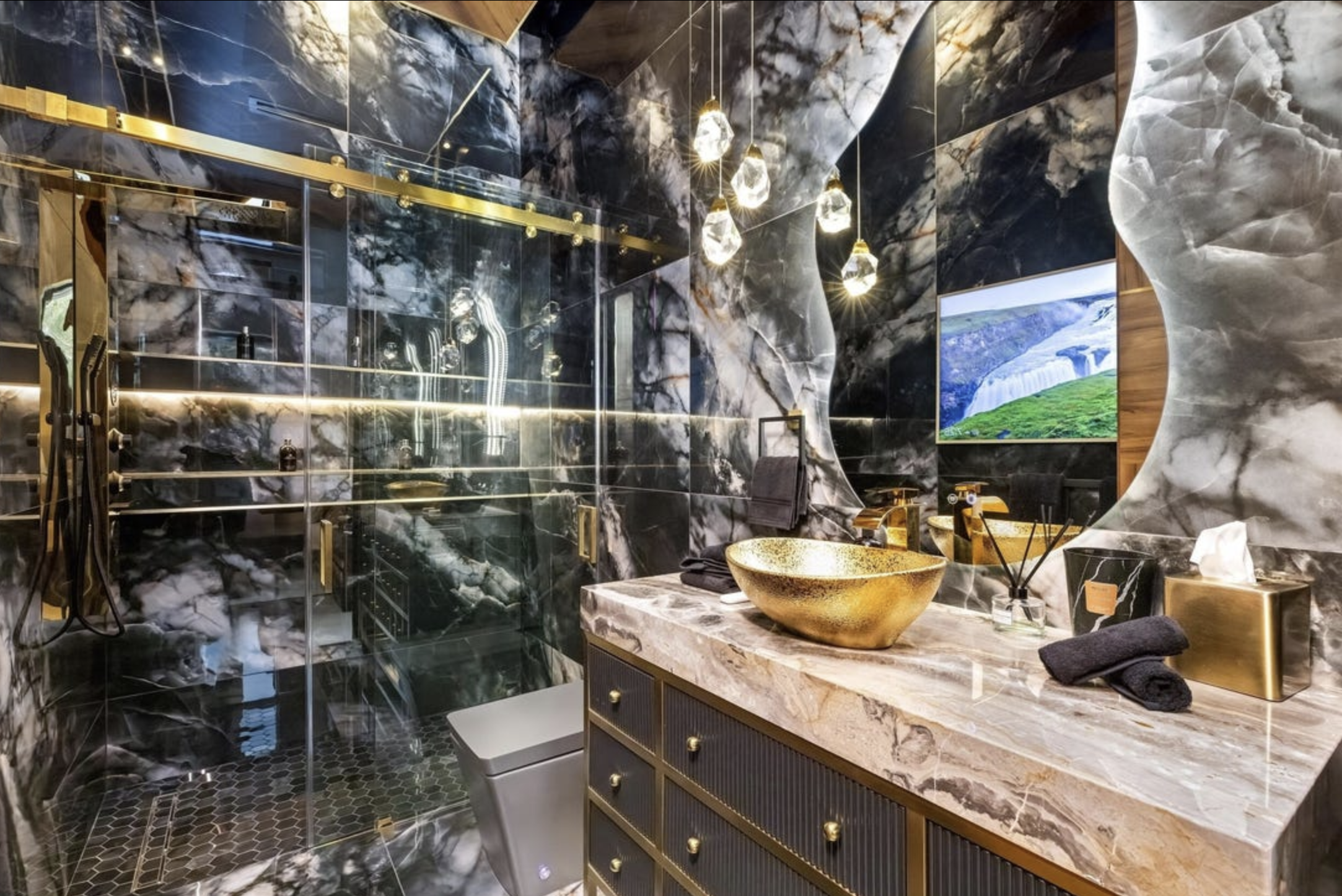 A bathroom with the walls clad entirely in patterned black marble and it's all reflective and extremely busy looking