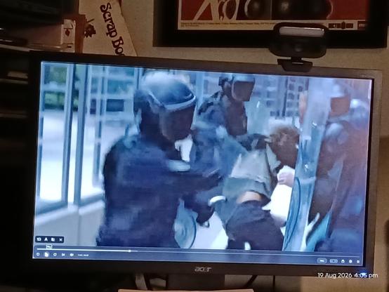 TV screen showing a scene from The Expanse of MPs beating protesters